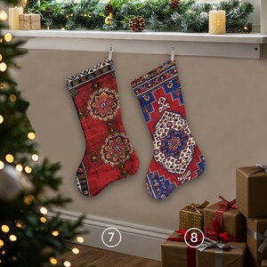 Pu&ograve; includere: Due calze di Natale con un design simile a un tappeto sono appese a dei ganci. Una &egrave; rossa con un motivo floreale, l'altra &egrave; rossa e blu con un design geometrico. I regali sono avvolti in carta marrone con nastri.