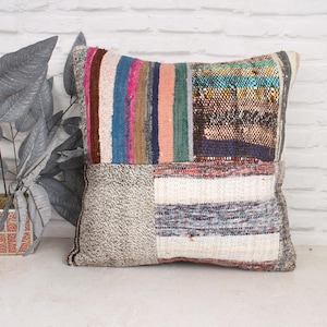 Peut inclure: Un coussin patchwork avec une variété de couleurs et de textures, y compris des rayures, des carreaux et des unis. Le coussin est fabriqué à partir de matériaux recyclés et a un aspect unique et fait main.