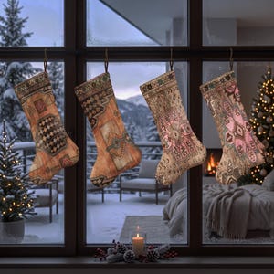 Könnte beinhalten: Vier Weihnachtsstrümpfe hängen in einer Reihe vor einem Fenster. Jeder Strumpf weist ein unverwechselbares, kompliziertes Webmuster in Orange-, Beige-, Rosa- und Brauntönen auf, das an traditionelle Teppichdesigns mit geometrischen und floralen Motiven erinnert.