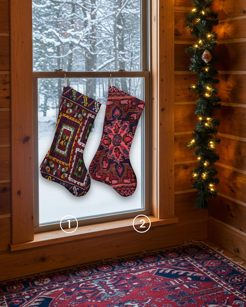 Pu&ograve; includere: Due calze di Natale decorate sono appese davanti a una finestra innevata. Una &egrave; principalmente bordeaux con disegni geometrici verdi, gialli e bianchi. L'altra &egrave; rossa con un motivo floreale. Una ghirlanda con luci decora la parete di legno.