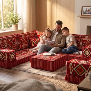 May include: A modular floor sofa set featuring a vibrant red base with intricate geometric patterns in white, green, and yellow. The set includes low-profile seating cushions, backrests, and a matching square ottoman, all upholstered in a traditional textile.