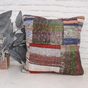 Peut inclure: Une housse de coussin en patchwork coloré avec une variété de couleurs et de textures, notamment du rouge, du bleu, du vert et du blanc.