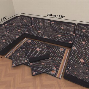 May include: A black sectional sofa with a patterned design, measuring 130 inches long, 75 inches wide, and 28 inches deep. Includes matching throw pillows and a rug with a similar pattern. The sofa is placed on a wooden floor.