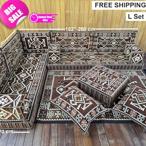 Op de afbeelding: Een L-vormige bankstel met een bijpassend vloerkleed, twee poefs en twee kussens. De set heeft een bruin en beige geometrisch patroon. De bank is 260 cm lang, 190 cm breed en de poef is 70 cm breed. De afbeelding bevat een "Big Sale" sticker.