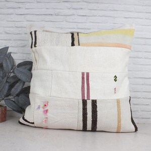 Puede incluir: Funda de cojín blanca de patchwork con rayas marrones, rosas y amarillas. La funda de cojín está hecha de un tejido suave y tejido y tiene un aspecto rústico y vintage.