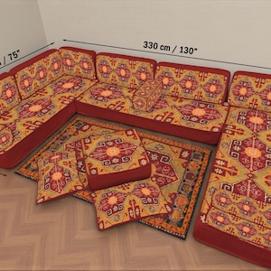 May include: An L-shaped sofa with a patterned design in red, yellow, and orange. The sofa measures 130 inches long, 75 inches wide, and 28 inches deep. Several matching throw pillows and a rug are also visible.