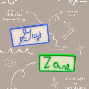 Op de afbeelding: Aangepaste magneten met handgeschreven namen, "Guy" in blauw en "Zane" in groen. De tekst "koester de handschrift van uw kleintjes" en "Geweldige cadeaus voor ouders en grootouders" is ook zichtbaar. Perfect om kunstwerken op te hangen.