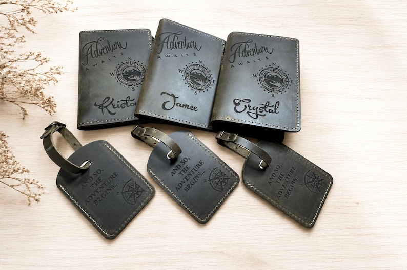 Puede incluir: Tres fundas para pasaporte de color gris oscuro y tres etiquetas de equipaje a juego. Cada funda muestra el texto Adventure Awaits, un gr&aacute;fico de br&uacute;jula y un nombre. Cada etiqueta muestra el texto And so, the adventure begins y una br&uacute;jula.