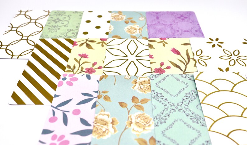 Peut inclure: Un ensemble de 12 carr&eacute;s de papier &agrave; motifs avec des accents dor&eacute;s. Les motifs comprennent des rayures, des pois, des fleurs et des motifs g&eacute;om&eacute;triques.