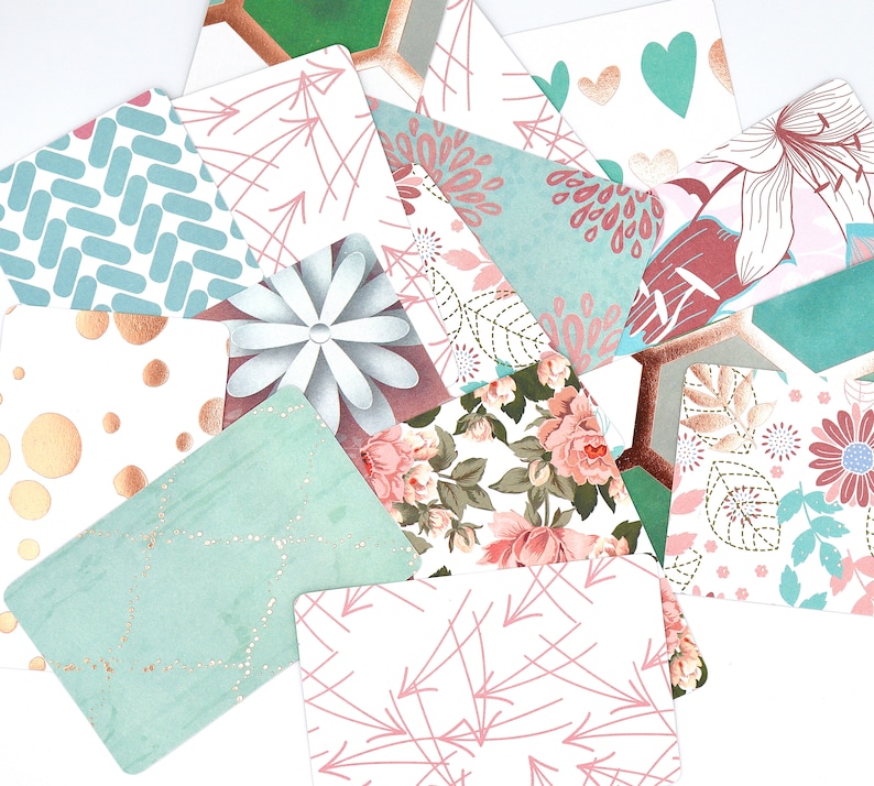 Peut inclure: Un ensemble de cartes d&eacute;coratives avec diff&eacute;rents motifs et designs. Les cartes pr&eacute;sentent un m&eacute;lange de motifs floraux, g&eacute;om&eacute;triques et abstraits dans des tons de rose, bleu et blanc.
