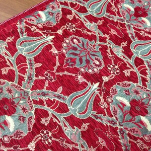 May include: Red fabric with a floral pattern featuring gray and white tulips and leaves.