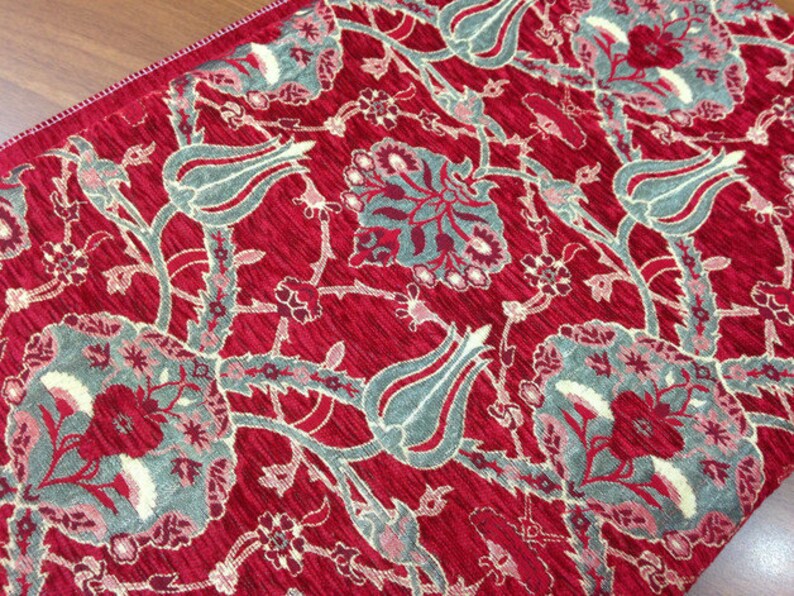 May include: Red fabric with a floral pattern featuring gray and white tulips and leaves.