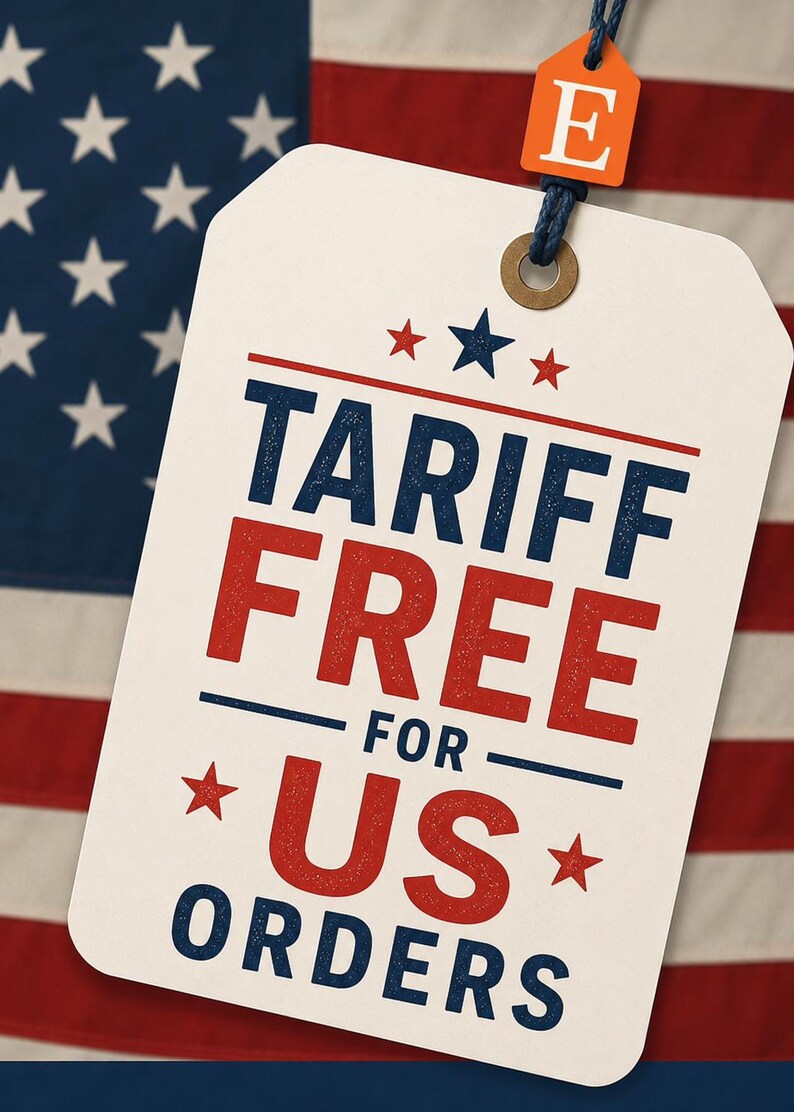 Może przedstawiać: Biała prostokątna etykieta z zaokrąglonymi rogami, zawierająca niebiesko-czerwony napis TARIFF FREE FOR US ORDERS, ozdobiona małymi czerwonymi i niebieskimi gwiazdkami. Mała pomarańczowa etykieta z białą literą E jest przymocowana niebieskim sznurkiem.