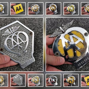 May include: Two vintage metal AA car badges featuring the iconic winged emblem. One badge is a silver-toned hexagonal plaque with a textured background and the number 231200. The other is a rounded badge with yellow enamel and the number OP32680.