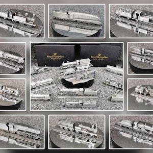 May include: A selection of silver-coloured model train locomotives and carriages, presented on circular bases. The models showcase diverse designs, including coal cars and passenger carriages. The image features multiple views of the trains, and a box with the text "Royal Hampshire".