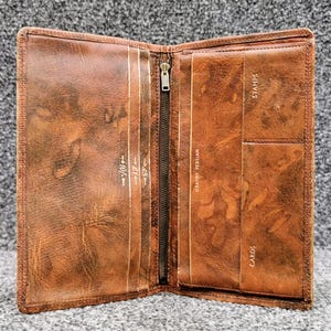 Cartera vintage de piel persa Granby, diseño de mármol, detalles dorados y bolsillo con cremallera.