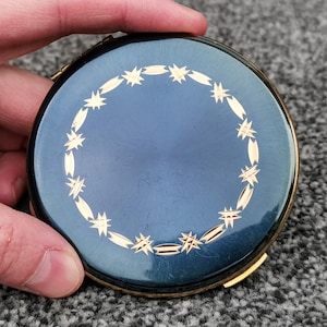 Könnte beinhalten: Ein Set aus drei Keramikbechern mit gesprenkelter, matter Oberfläche. Die Becher sind in Creme-, Hellgrau- und Dunkelgrautönen gehalten. Jeder Becher hat ein schlichtes, minimalistisches Design.