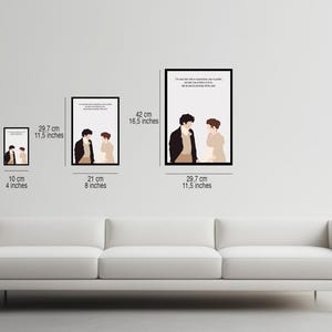 May include: Four framed prints of a couple in a minimalist style. The prints are in black frames and feature a quote from a book. The prints are arranged in a row on a white wall above a white couch. The largest print is 42 cm by 16.5 inches, the next largest is 29.7 cm by 11.5 inches, the next is 21 cm by 8 inches, and the smallest is 10 cm by 4 inches.