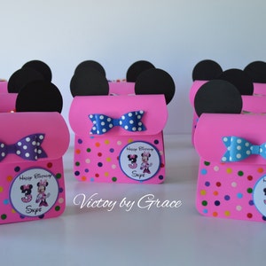 Puede incluir: Bolsas de regalo de fiesta de Minnie Mouse de color rosa y negro con patrones de lunares y un lazo. Cada bolsa tiene una pegatina personalizada con una imagen de Minnie Mouse y el nombre "Skye".
