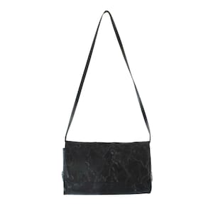 May include: A black leather crossbody bag with a textured pattern. The bag has a long strap and a flap closure.