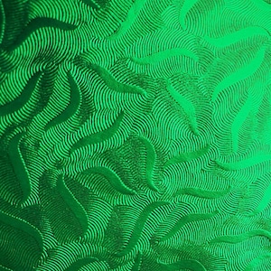 Puede incluir: Primer plano de un papel texturizado verde brillante con un patrón de remolino.