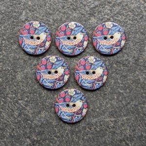May include: Six round wooden buttons with a bird and berry design. The buttons feature a cream-colored bird with a brown speckled chest, surrounded by red berries and blue leaves on a navy background.