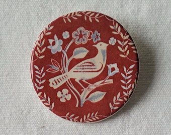 Round, handmade, ceramic, red bird brooch from a design found in The Warner Textile Archive. A lovely gift for any occasion