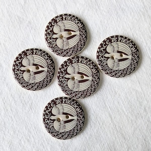 May include: Five brown ceramic buttons with white doves and the text "Peace is Freedom" in a circular design.
