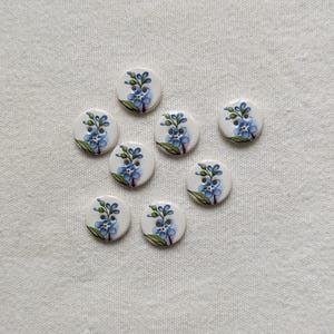 8 handgemaakte, keramische vergeet-me-nietjesknopen van 15 mm (iets meer dan 1/2 inch), wasbaar en lichtgewicht.