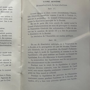 May include: A vintage book page with French text, featuring the title "Dissolution-Liquidation" and legal articles. The page is aged with visible wear and tear, and the text is in black ink.