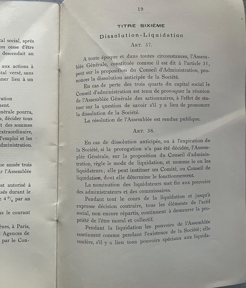 May include: A vintage book page with French text, featuring the title "Dissolution-Liquidation" and legal articles. The page is aged with visible wear and tear, and the text is in black ink.
