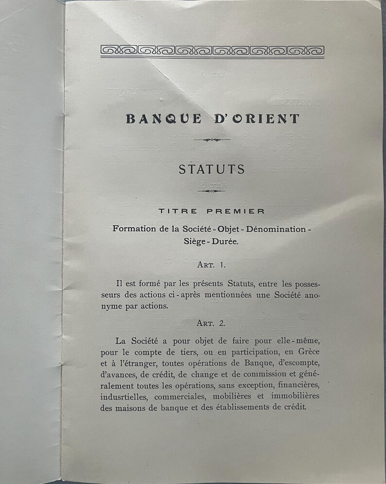 May include: A vintage document with the title "BANQUE D'ORIENT" and the word "STATUTS" in large, bold letters. The document is in French and details the formation and objectives of a company, including financial operations.