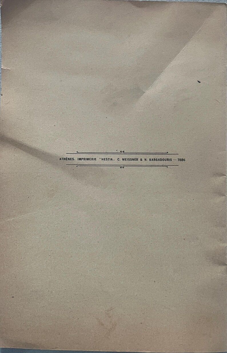 May include: Aged tan paper with creases and imperfections. The text "ATHENES. IMPRIMERIE "HESTIA.. C. MEISSNER & N. KARGADOURIS - 7886" is printed in black near the bottom. The paper has a vintage appearance.