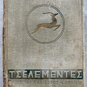 May include: Vintage book cover with a light gray linen texture. A brown gazelle is inside a double circle. The title "ΤΣΕΛΕΜΕΝΤΕΣ" is printed in dark green, with additional text below. The book shows signs of age.