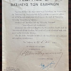 May include: A vintage off-white official document from 1945 featuring Greek text, a royal emblem at the top, and handwritten signatures in blue and black ink. The paper shows signs of age with creases and a stamp in the upper right corner.
