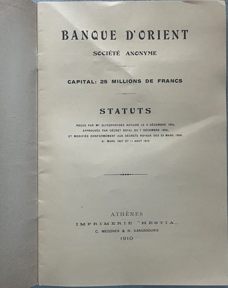 May include: A vintage document from 1910, featuring the text "BANQUE D'ORIENT" at the top. The document is printed in black ink on aged paper and includes the text "SOCI&Eacute;T&Eacute; ANONYME" and "CAPITAL: 25 MILLIONS DE FRANCS".