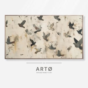 Puede incluir: Una obra de arte enmarcada que representa una bandada de pájaros en vuelo. Las aves están representadas en tonos grises y marrones sobre un fondo texturizado blanquecino. La obra está enmarcada en un fino borde de tono metálico. El texto "ARTØ VINTAGE FRAME TV ART" está en la parte inferior.