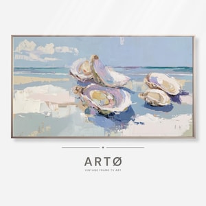 May include: An oil painting on canvas depicts oysters on a beach with a light blue sky and ocean in the background. The artwork is framed in a gold-colored metal frame. The text "ARTØ VINTAGE FRAME TV ART" is at the bottom.