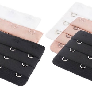 May include: Set of six bra strap extenders in black, white, and nude colors. Each extender has three rows of hooks and eyes.