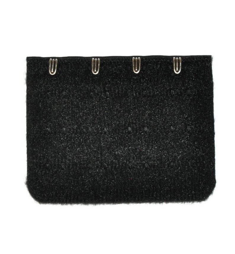 May include: Black fabric with four silver hooks along the top edge. The fabric has a fuzzy texture.