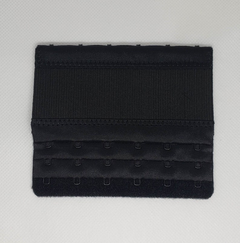 Peut inclure: Un extenseur de soutien-gorge noir avec trois rang&eacute;es de fermetures &agrave; crochet et &oelig;illet. L'extenseur est fait d'un tissu textur&eacute; et a une forme rectangulaire. Les crochets sont de couleur argent.
