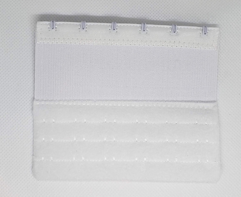 Peut inclure: Une extension de soutien-gorge blanche avec trois rang&eacute;es de fermetures &agrave; crochet et &oelig;illet. L'extension est faite d'un tissu doux et textur&eacute; et pr&eacute;sente une construction robuste. Les crochets sont de couleur argent&eacute;e.