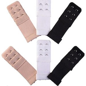 Op de afbeelding: Een verzameling bh-verlengers in beige, wit en zwart. Elke verlenger heeft drie sets haak-en-oogsluitingen, voor verstelbare maten. De verlengers zijn gemaakt van een zachte, geribbelde stof.