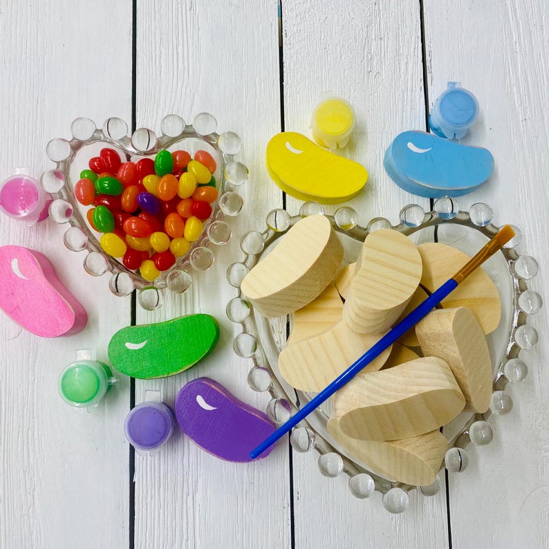 May include: A craft kit for painting wooden jelly bean shapes. The kit includes a heart-shaped bowl filled with colorful jelly beans, paint pots, a paintbrush, and wooden jelly bean shapes.
