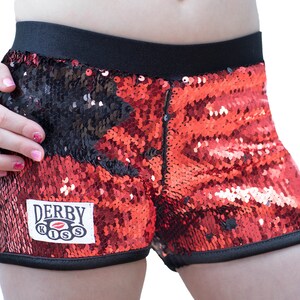 May include: Red and black sequined shorts with a black waistband and a white patch that says "Derby Kiss" with a red lip design.