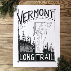 May include: A black and white illustration of the Long Trail in Vermont. The illustration shows the trail winding through the Green Mountains, with the text "footpath in the wilderness" and "LONG TRAIL" printed below the map.