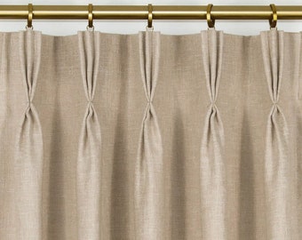 May include: Beige linen curtains with pleats hanging from a gold rod.