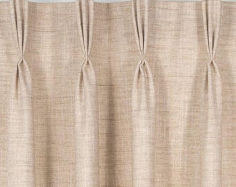 May include: Beige curtains with pleats hanging from a gold rod.