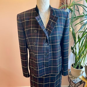 May include: A black, red and yellow plaid skirt suit with a double-breasted jacket.