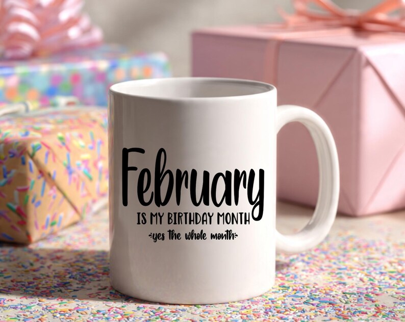 May include: White ceramic mug with the text "February is my birthday month - yes the whole month" in black script. The mug has a curved handle and is surrounded by wrapped gifts.